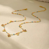 Gold heart charm necklace worn - view 2