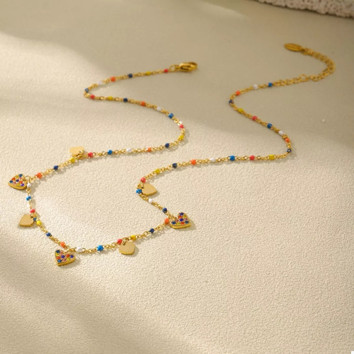 Gold heart charm necklace worn - view 2