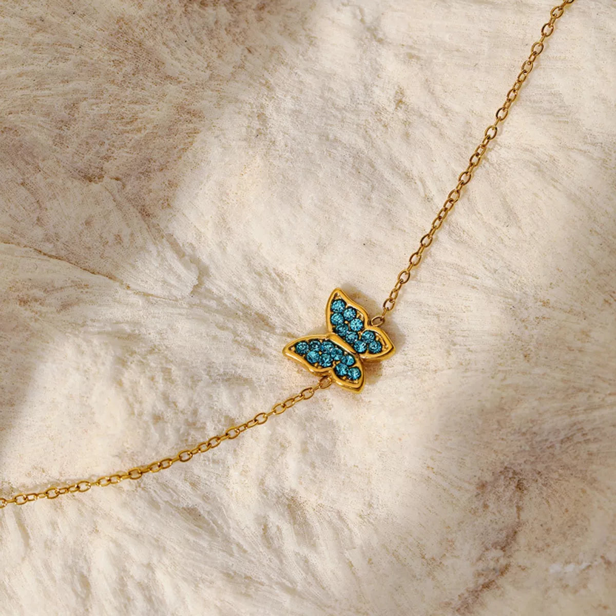 Gold butterfly bracelet on wrist - view 2